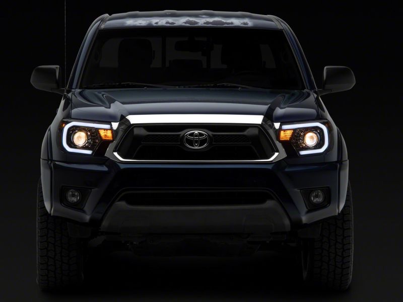 Raxiom 12-15 Toyota Tacoma Axial Projector Headlights w/ SEQL LED Bar- Black Housing (Clear Lens)